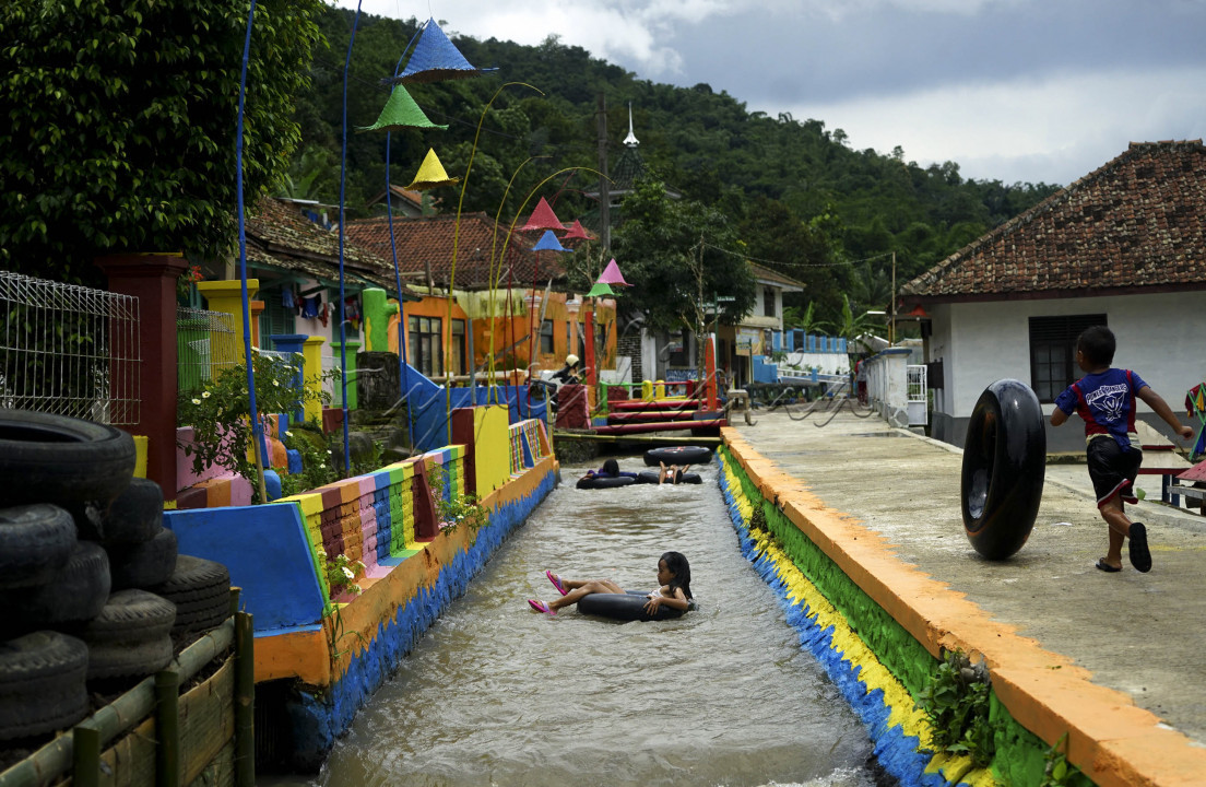 <br />
Anak-anak mengarungi aliran irigasi menggunakan ban dalam bekas di Kampung Kreatif Babakan&nbsp;Caringin, Desa Cipanas Kecamatan Tanjung Kerta, Kabupaten Sumedang. Keberadaan aliran irigasi mata air Cikandung dimanfaatkan karang taruna setempat sebagai wahana bermain anak dengan menyewakan ban sebagai pelampung renang seharga Rp 2 ribu per jam. Selain berpotensi menambah pendapatan bagi karang taruna, wahana&nbsp;tubing&nbsp;di Kampung Kreatif Babakan&nbsp;Caringin&nbsp;ini menjadi upaya untuk mengangkat potensi wisata desa.&nbsp;&nbsp;&nbsp;