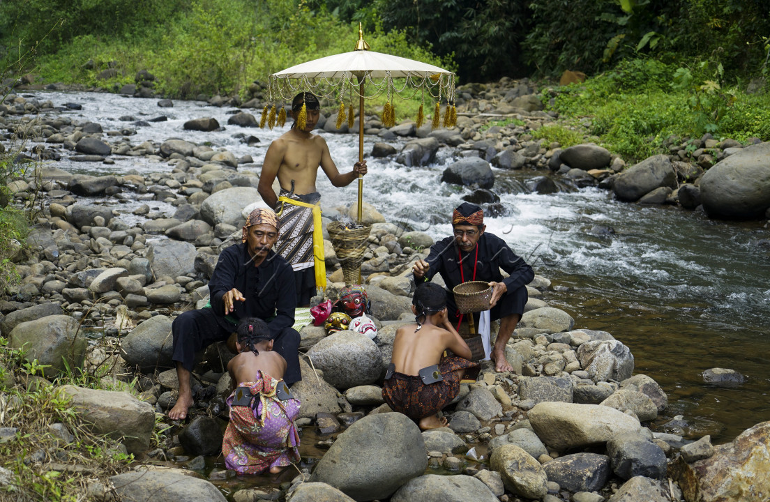 Tokoh adat Sunda Kabupaten Sumedang dan sesepuh Dusun Sanding menaburkan bunga saat prosesi "Ngaruwat&nbsp;Wahangan" di Leuwi Seeng, aliran Sungai Cicapar Desa Kaduwulung Kecamatan Situraja, Kabupaten Sumedang. Ngaruwat&nbsp;Wahangan&nbsp;ini merupakan salah satu prosesi meminta ijin pada pemilik semesta alam dan wujud syukur atas apa yang telah diberikan pada manusia terutama warga yang hidup di aliran sungai. Prosesi ini dilakukan oleh warga Dusun Sanding sebagai ungkapan syukur atas berkah semesta alam berupa aliran sungai yang mengaliri lahan dan sawah milik warga serta menjadikan objek wisata yang mampu bernilai ekonomi bagi warga sekitar.<br />
<br />
Prosesi Ngaruwat&nbsp;Wahangan&nbsp;dipimpin oleh seorang tokoh adat yang membuka prosesi dengan rajah dan kidung puji-pujian bagi leluhur mereka. Tokoh adat tersebut akan memercikkan air dan menaburkan bunga di kepala warga sebagai simbol kebersihan dan keindahan selalu mengiringi hidup para penerus generasi di kampungnya. Selanjutnya warga akan membawa air sungai ke dalam kendi yang terbuat dari tanah untuk dibagikan pada warga lainnya sebagai tanda keberkahan terus menerus yang dapat dinikmati oleh seluruh warga di Dusun Sanding.