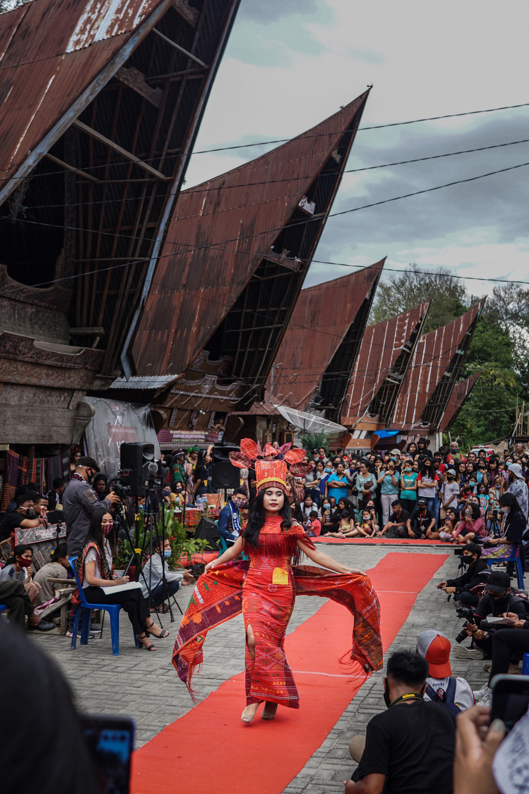 Seorang peraga menampilkan design Ulos diatas karpet merah di Kampung Ulos Lumban Suhi-suhi, Samosir
