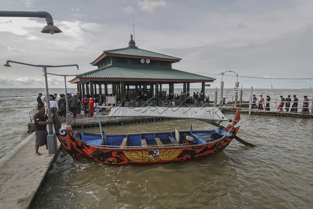 Sejumlah peziarah menggunakan jasa perahu menuju makam Simbah Kiai Abdullah Mudzakkir yang dijuluki &lsquo;Makam Terapung&rsquo; di pesisir Desa Bedono, Kecamatan Sayung, Kabupaten Demak, Jawa Tengah, Jumat 19 November 2021. Peziarah yang datang dari dalam maupun luar Kabupaten Demak tujuannya untuk mendapatkan berkah dan berwisata religi di makam kiai penyebar agama Islam pada sekitar 1900-1950 di daerah setempat