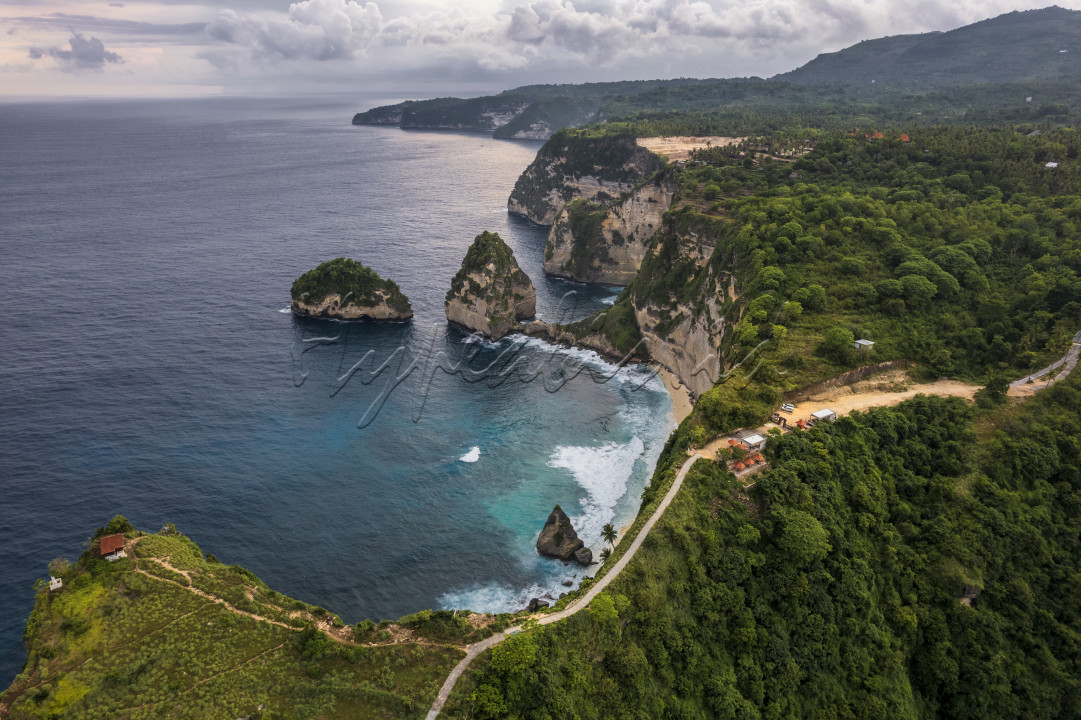 Diamond Beach&nbsp;di Nusa Penida.<br />
Tempat wisata baru di Nusa Penida&nbsp;ini mendapatkan namanya dari tebing-tebing karst yang mengelilingi sekitar pantai.<br />
Karena posisinya yang tersebar di beberapa titik tebing, tebing batu karst runcing ini terlihat seperti hamparan permata.&nbsp;<br />
Tidak heran jika akhirnya lokasi pantai ini dikenal dan dinamai dengan&nbsp;Diamond Beach.<br />
Selain karena kemilau dari tebing yang terkena cahaya matahari, pasir putih di pantai ini juga menjadi permata tak ternilai yang pasti dicari-cari pecinta pantai.<br />
Dulunya, tempat ini bahkan tidak bisa di akses dan wisatawan yang bisa menikmati pemandangan dari atas tebing saja.<br />
Sebelum menjadi lokasi wisata, hanya warga setempat saja yang bisa mengakses keindahan tempat ini karena jalan dari atas tebing menuju ke bawah pantai sangat terjal.<br />
Para wisatawan harus bersyukur dan berterima kasih kepada warga setempat karena membuat akses bagi pengunjung dengan membuat tangga dan jalan setapak.<br />
Dengan akses ini, wisatawan pun bisa dengan leluasa menikmati&nbsp;Diamond Beach.