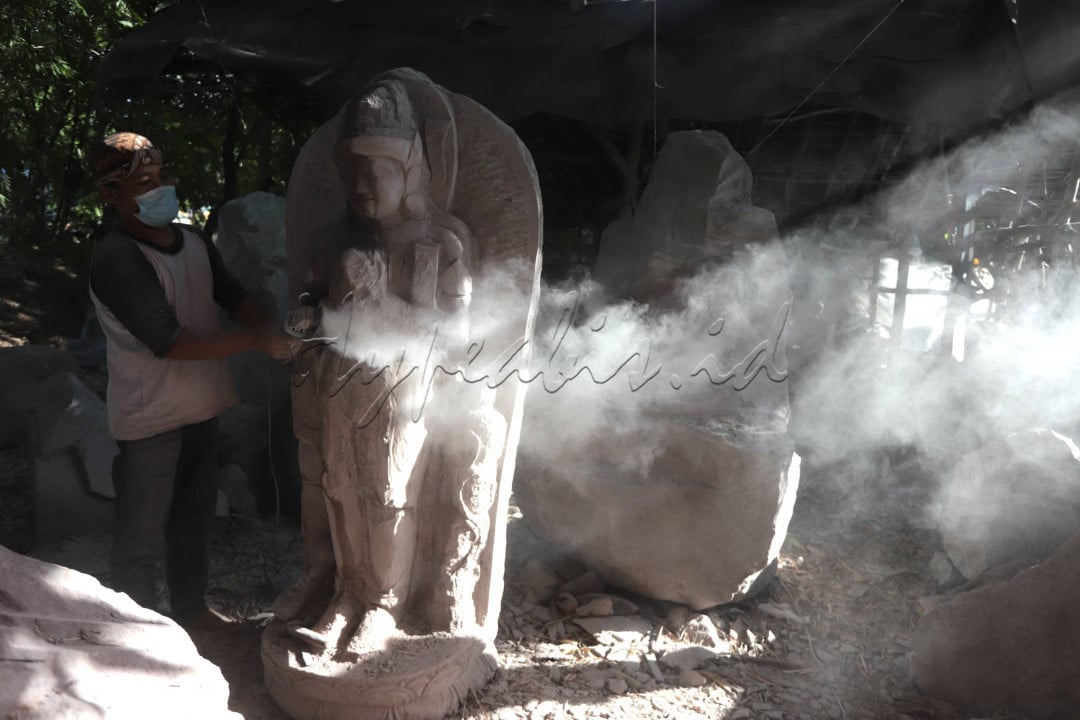 Perajin menyelesaikan pembuatan patung berbahan batu di Trowukan Mojokerto Jawa Timur Juni lalu, Trowulan merupakan wilayah bekas kerajaan Majapahit, permintaan patung khas majapahitan tersebut tembus pasar internasional, namun beberapa waktu lalu sempat terhenti karena kendala pandemi.