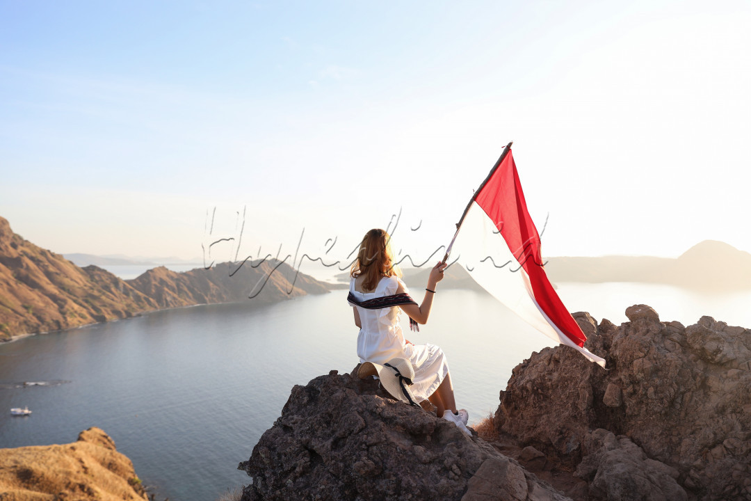 Seorang gadis yang sedang menikmati keindahan alam dari atas bukit Pulau Padar
