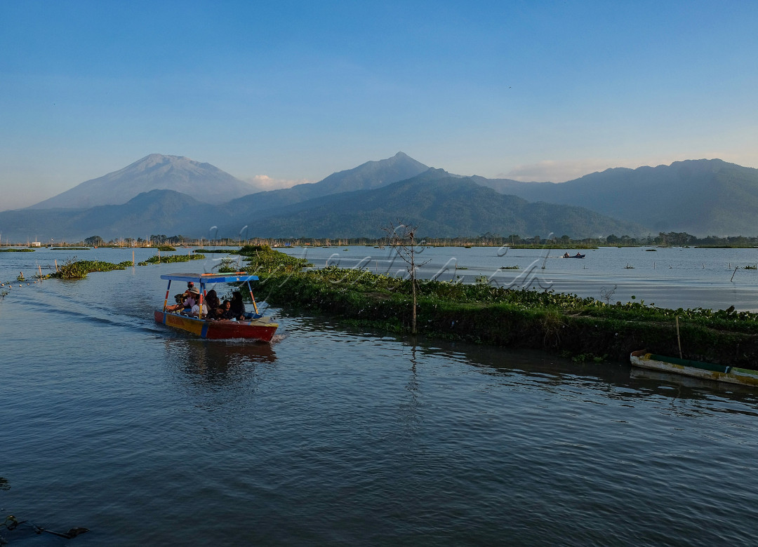 Rawa Pening merupakan salah satu objek wisata alam danau dengan luas 2.670 hektare yang terletak di Kecamatan Ambarawa, Bawen, Tuntang dwn Banyubiru, Kabupaten Semarang, Jawa Tengah. Rawa Pening terletak di cekungam terendag lereng Gunung Merbabu, Gunung Telomoyo dan Gunung Ungaran. Kita tidak hanya bisa singgah di sekitar danau dan menikmati keindahan danau, namun kita juga bisa menyewa perahu untuk berkeliling danau rawa pening. Tarif untuk menyewa perahu adalah Rp. 100.000 selama 15menit. Saat berkeliling danau, kita bisa melihat banyak tanaman enceng gondok yang tersebar di permukaan danau Rawa Pening. Selain itu, pemandangan di sepanjang danau juga sangat indah dengan latar belakang gung Telomoyo, gunung Ungaran dan gunung Merbabu. Di sepanjang danau juga terdapat pondok terapung milik nelayan yang mencari ikan di danau Rawa Pening. Untuk keselamatan, penumpang disediakan pelampung yang dikenakan penumpang saat menyusuri danau Rawa Pening menggunakan perahu.<br />
<br />
<br />
&nbsp;