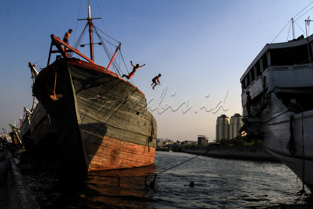 Sejumlah anak melompat dari atas kapal pengangkut barang yang bersandar di dermaga Pelabuhan Sunda Kelapa, Jakarta, Jumat (28/08). Ditengah pandemi Covid-19 sejumlah anak yang tinggal di pesisir melatinh ketangkasan bersama dengan berenang di Pelabuhan Sunda Kelapa.&nbsp;