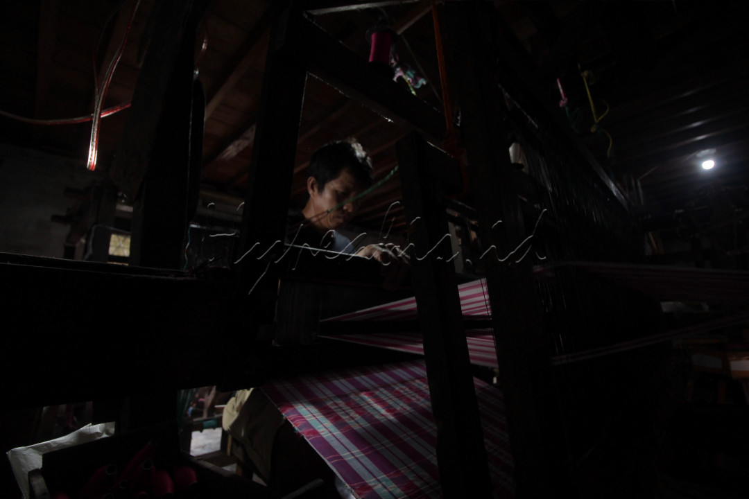 Judul : Alat Tradisional<br />
Pengrajin menenun kain tajung khas Palembang produksi rumahan dengan menggunakan alat tradisonal di kediamannya, kawasan Tuan Kentang, 15 Ulu, Kota Palembang, rabu, 20 artiOktober 2021.&nbsp;