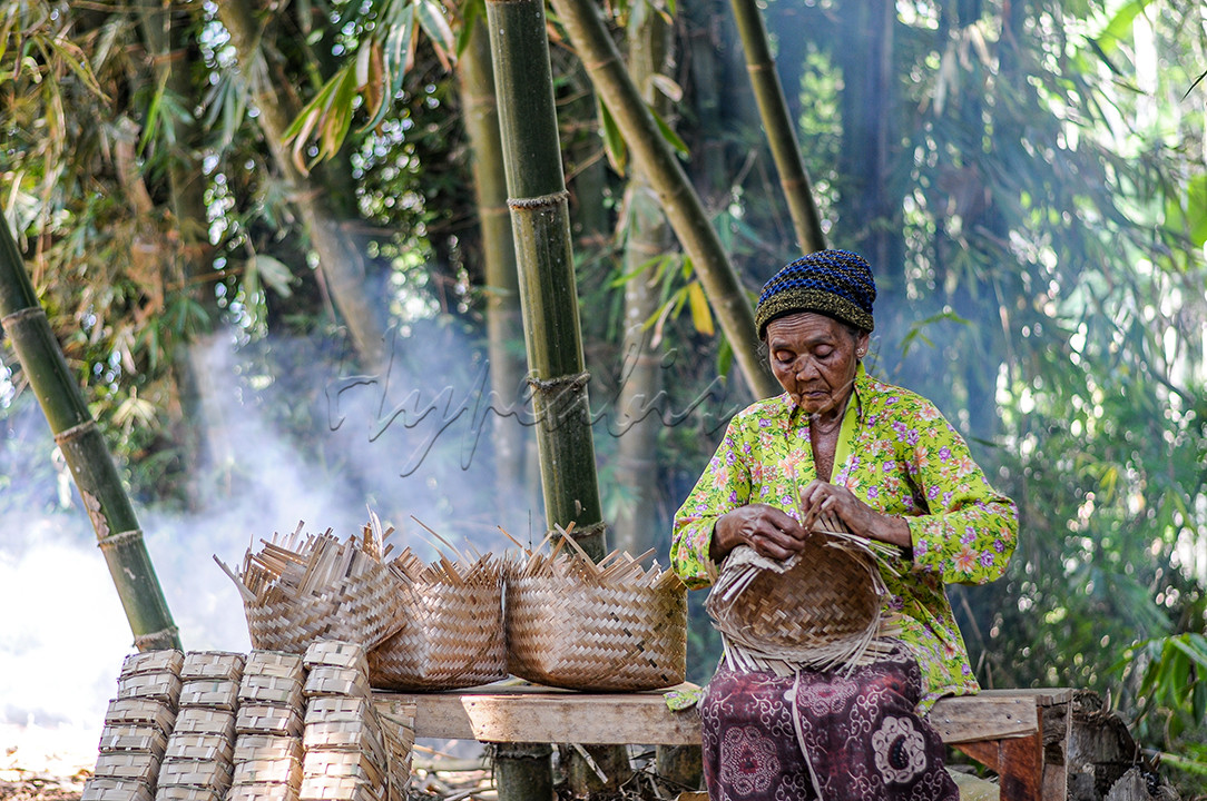 Seorang nenek tetap setia menekuni pekerjaan sebagai pembuat perkakas dari anyaman bambu, di tengah-tengah gencarnya penggunaan wadah dari bahan plastik.
