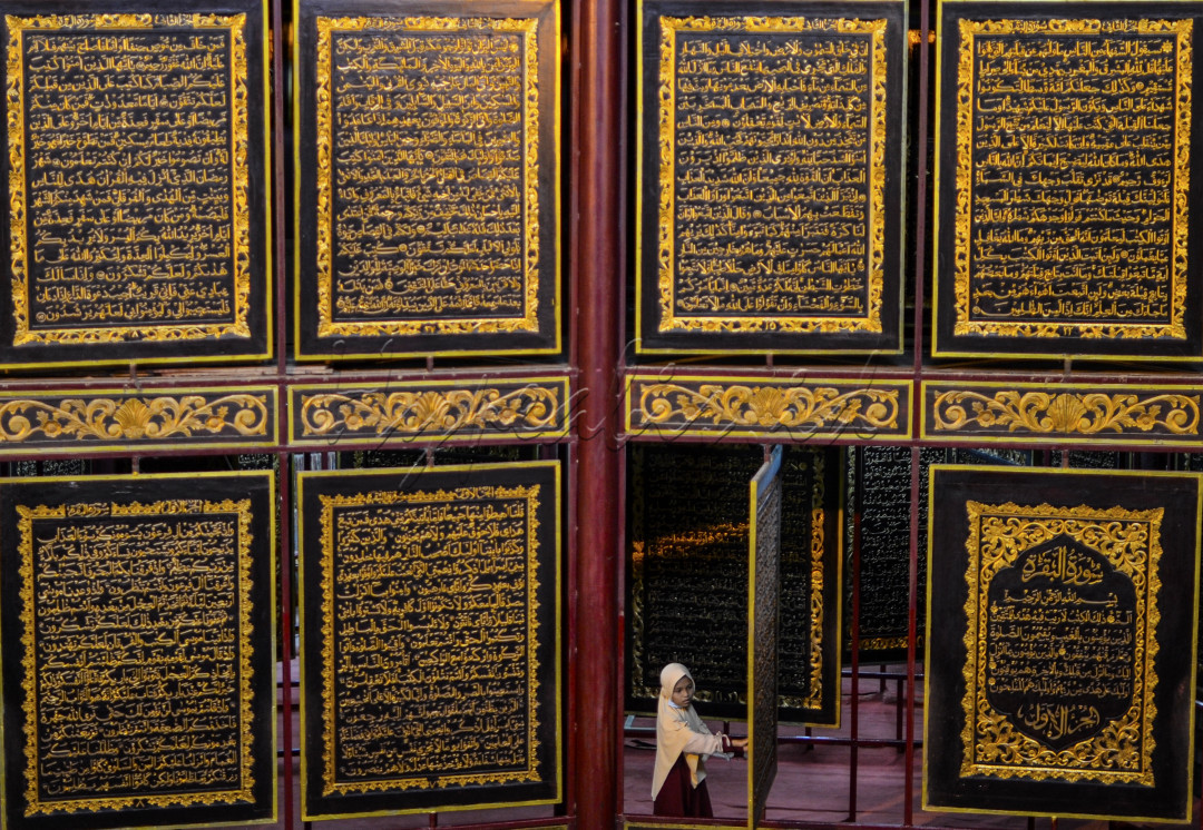 Seorang pengunjung melihat kemegahan Al-Quran Al-Akbar di Jalan Mohammad Amin, Kecamatan Gandus, Palembang, Selasa (4/5/2021). Al-Quran Al-Akbar atau sering disebut Al-Quran Raksasa ini merupakan destinasi wisata religi di kota Palembang.Al Quran Raksasa ini terbesar dan pertama di dunia dalam bentuk Al Quran 30 juz yang di buat pada media dari kayu jenis tembesu.masing-masing lembar ukuran halamannya 177 x 140 x 2,5 sentimeter dan tebal keseluruhannya termasuk sampul mencapai 9 meter.