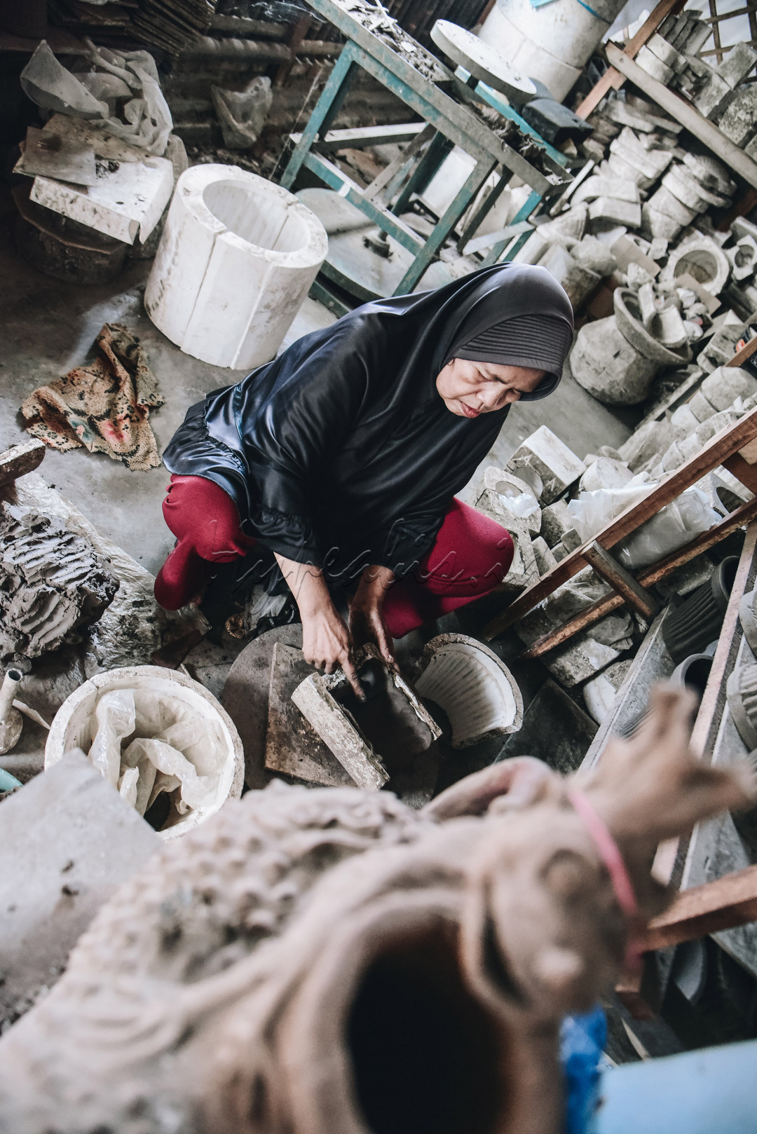 pengrajin wanita sedang membentuk kerajinan dari semen