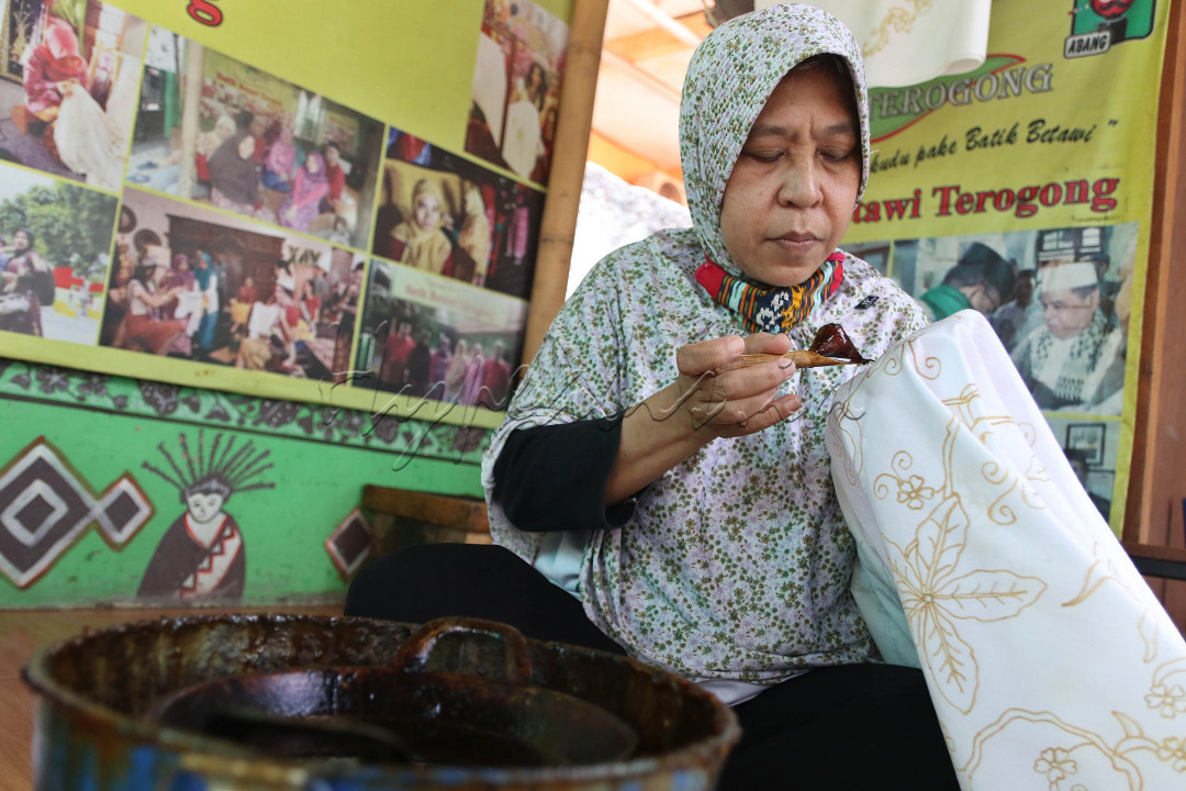 Perajin mewarnai kain batik khas Betawi mengunakan canting di Sanggar Batik Terogong, Cilandak, Jakarta. Batik identik dengan Indonesia. Hampir semua daerah di Tanah Air memiliki gaya batik tersendiri. Tak terkecuali di Ibu Kota. Salah satu tempat pelestarian batik di Jakarta ada di Kampung Batik Betawi Terogong yang telah berdiri sejak 2012.