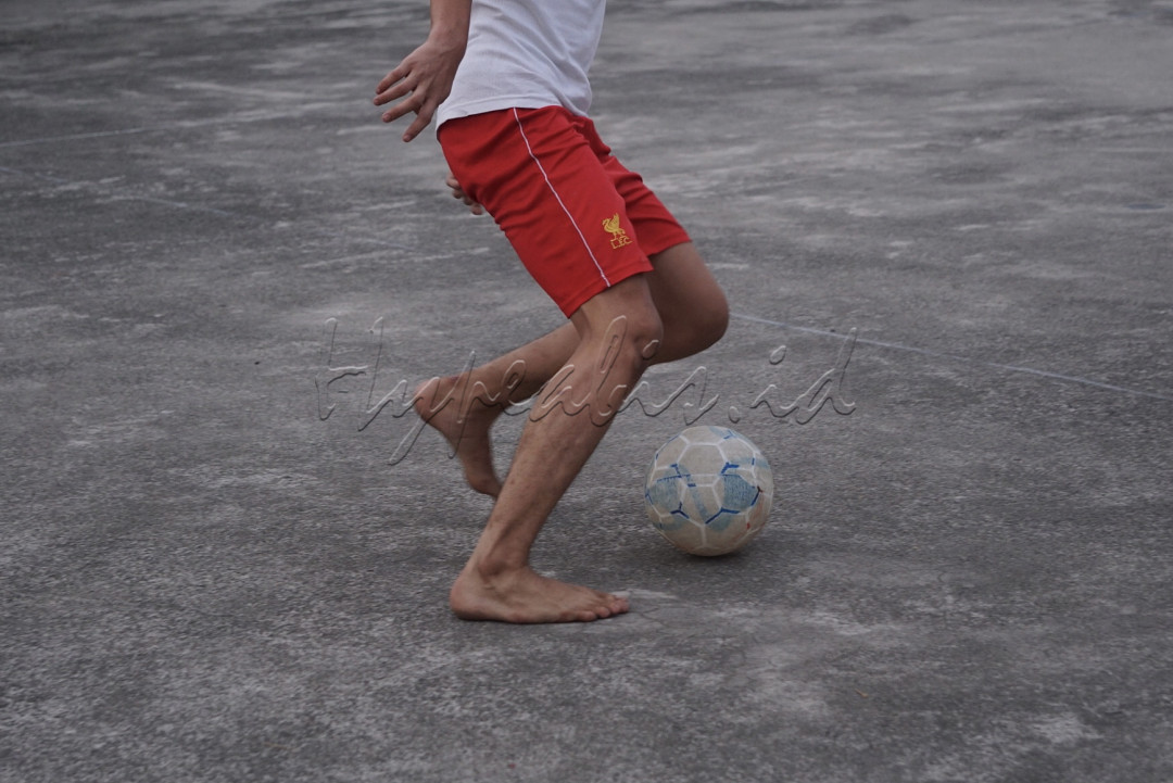 Walaupun bermain bola di atap gedung, anak-anak tersebut tetap riang dan bersemangat menggiring bola hingga mencetak gol.