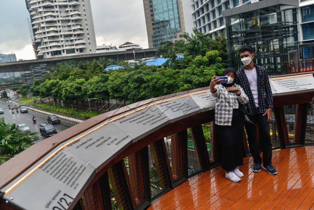 Warga berswafoto di atas jembatan penyeberangan orang (JPO) Karet Sudirman, Jakarta.