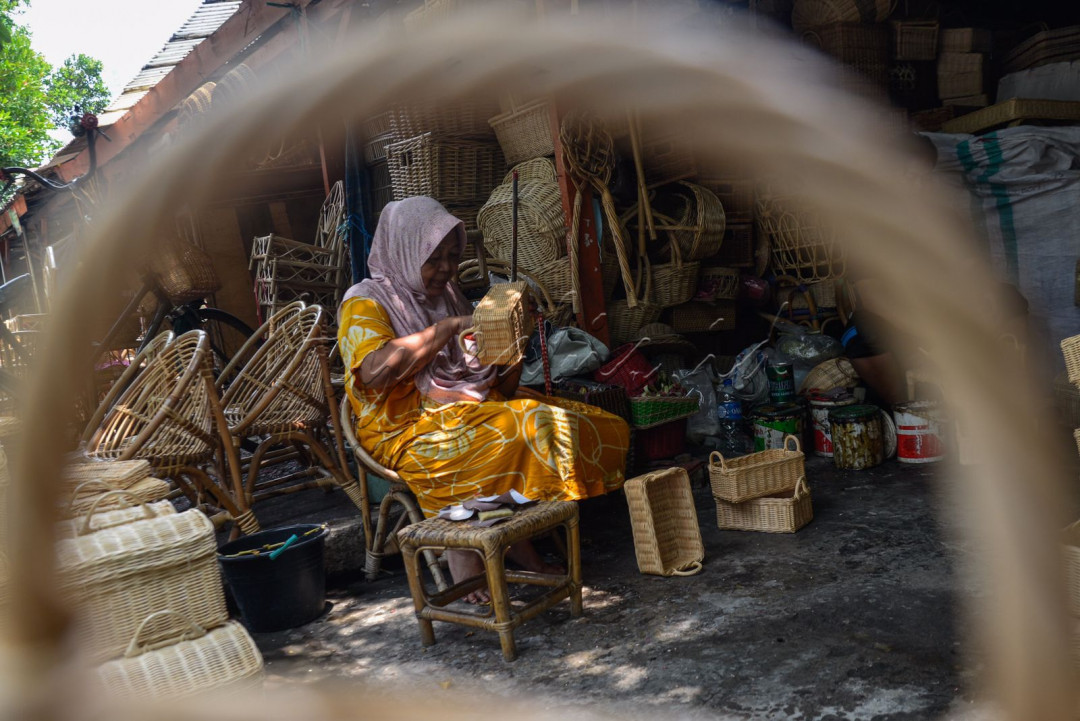 Perajin menyelesaikan pembuatan kerjainan tangan berbahan rotan di Jakarta.