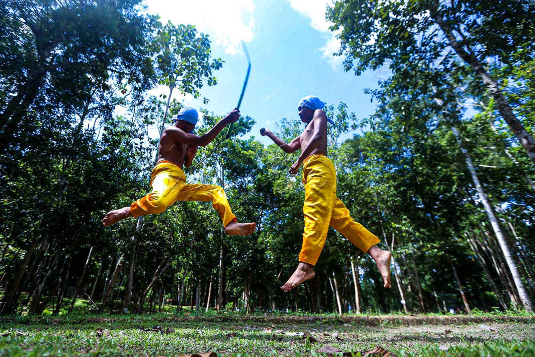 Dentuman alat musik tradisional seperti gong, tawak, kelinang dan serunai mengiringi dua orang pemuda memasuki gelanggang pertarungan.<br />
<br />
<br />
<br />
&nbsp;