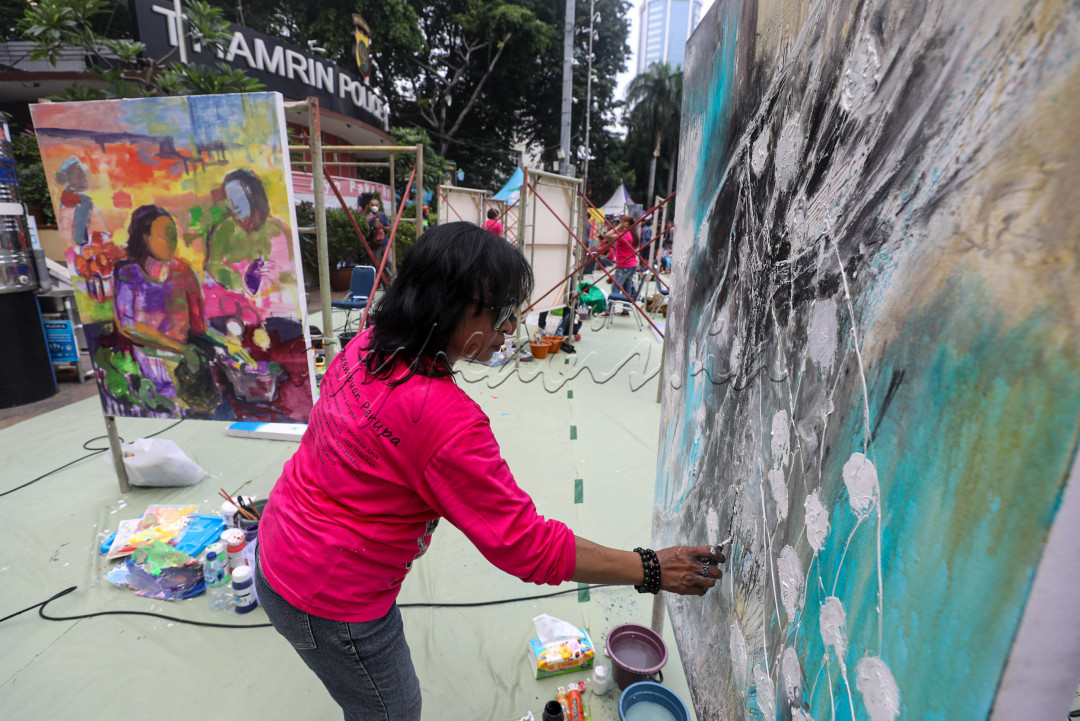 Beragam peralatan seni rupa menghampar di sekitar mereka.