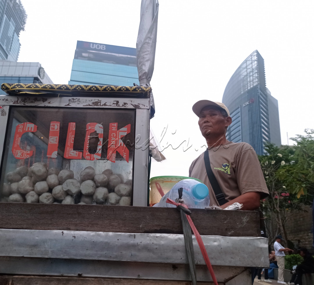 Pedagang cilok sedang menunggu pembeli di jalan Sudirman.&nbsp;