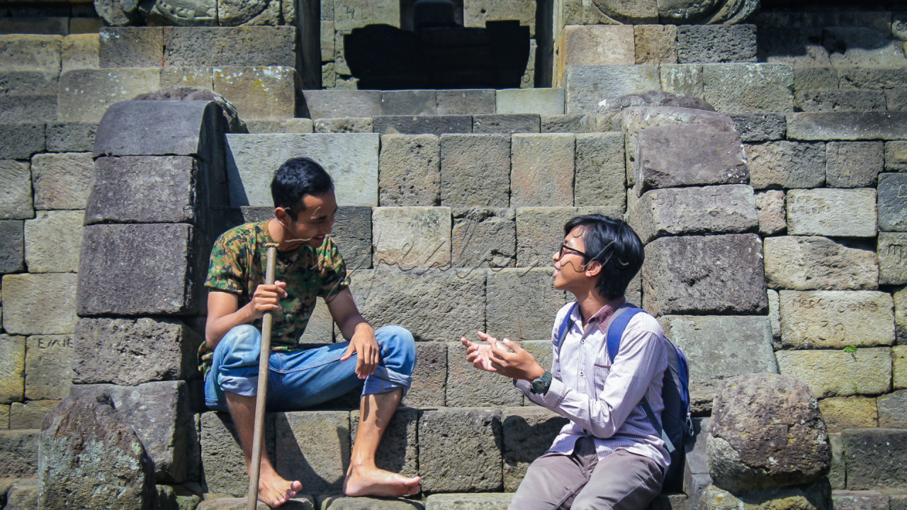 Pada foto ini mengambarkan <strong>symphony kegembiraan.</strong><br />
<br />
<strong>Mahasiswa</strong> (orang berkacamata dan beransel) berdiskusi dengan&nbsp;<strong>seorang penduduk asli</strong>&nbsp;berdiskusi tentang indahnya Indonesia, mereka berdua bertukar senyuman, untuk menciptakan suasana kehangatan.