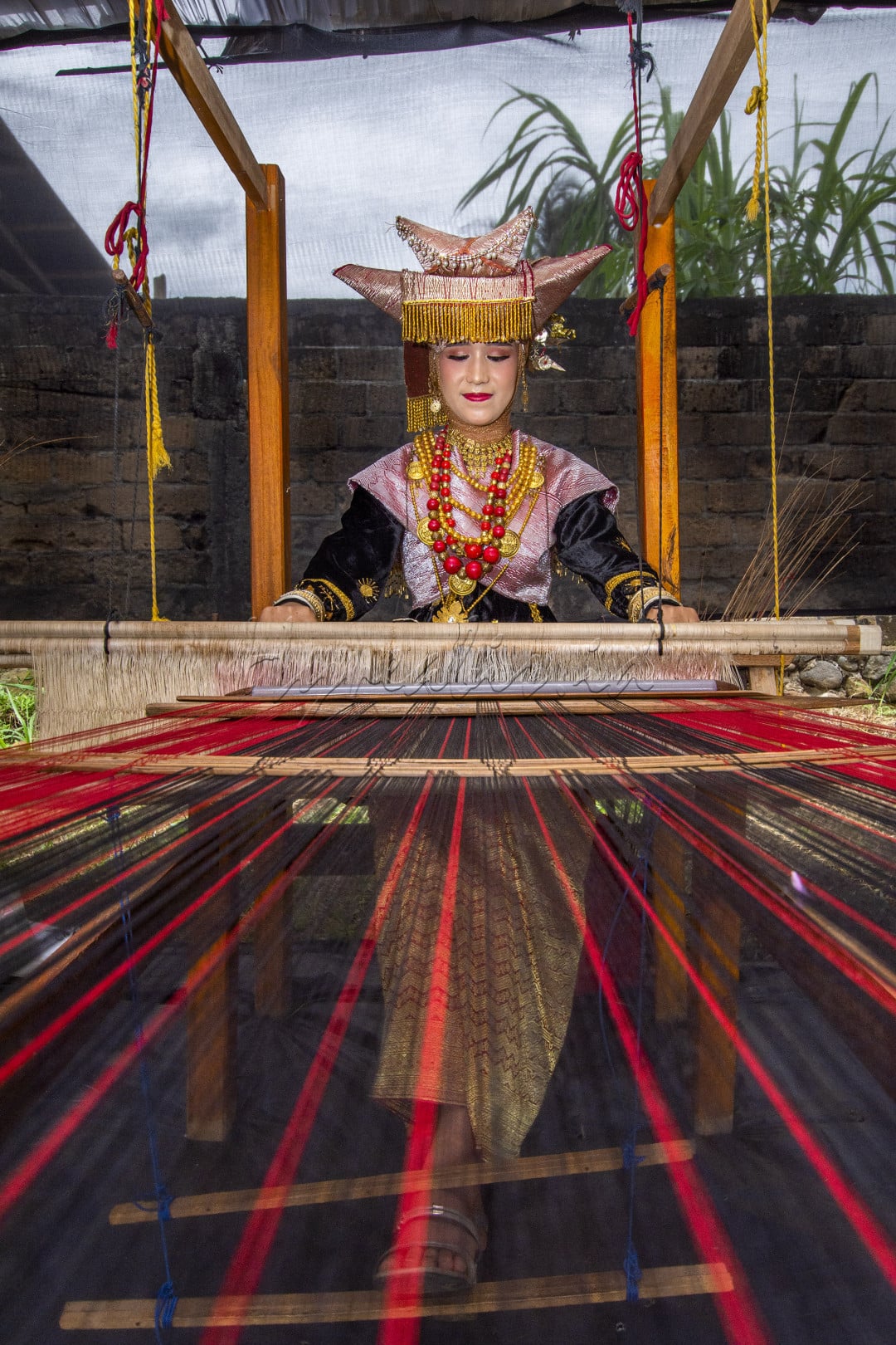 Seorang gadis minang menenun kain, menjadi songket yang punya nilai jual yang tinggi, banyak para gadis di minang yang masih mempertahankan budaya tenun secara tradisional.&nbsp;