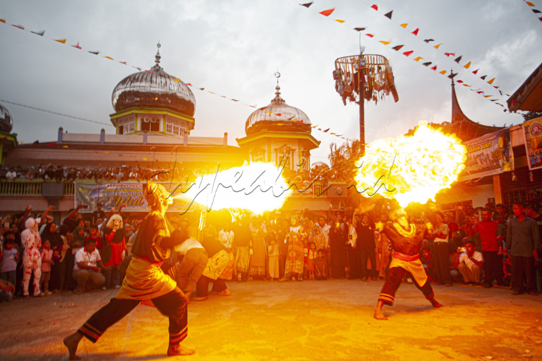 Atraksi api para pesilat pada Alek Nagari Andaleh untuk merayakan Idul Fitrti dan menyambu para perantau yang pulang kampung di Nagari Andaleh, Kabupaten Tanah Datar, Sumbar, Selasa (10/5/2022).