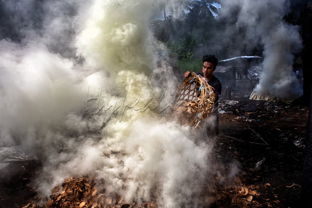 Seorang pria membakar batok kelapa untuk dijadikan arang di pabrik arang Desa Bengkaung, Lombok Barat. Arang yang dibakar ditempat ini dijual hingga ke luar pulau Lombok, bahkan ke luar negeri.