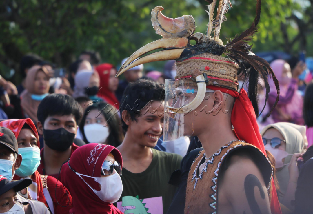 Peserta menggunakan pelindung wajah saat Festival Budaya Isen Mulang di Kota Palangka Raya, Kalimantan Tengah, pada Selasa (17/5/2022). Pemerintah kembali menggelar event tersebut di tengah pandemi dengan menerapkan protokol kesehatan, meskipun sempat terhenti dalam dua tahun terkahir akibat Covid-19. Foto: Risa Rahayu Kosasih.