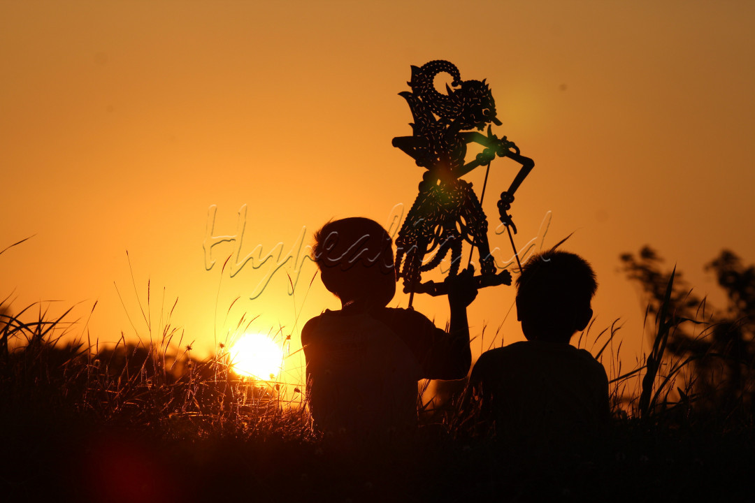 <div style="text-align: justify;">Wayang adalah salah satu warisan kebudayaan yang dimiliki oleh Indonesia. Keberadaan dan eksistensi wayang di era ini sudah seperti rotasi bumi yang mengelilingi matahari.<br />
Bahkan sinar dan hangat Sang Surya perlahan menghilang di kala senja. Ia terbit dan tenggelam atas kemauannya sendiri. Namun, wayang tak pernah bisa memilih kapan untuk terbit dan tenggelam. Nasibnya ada di tangan Sang Dalang dan cerita yang dibawakannya. Jika pemuda pemudi penerus bangsa di era ini tidak diajarkan mengenai sejarah dan budaya, bagaimana wayang akan bisa terbit dan bersinar kembali?</div>