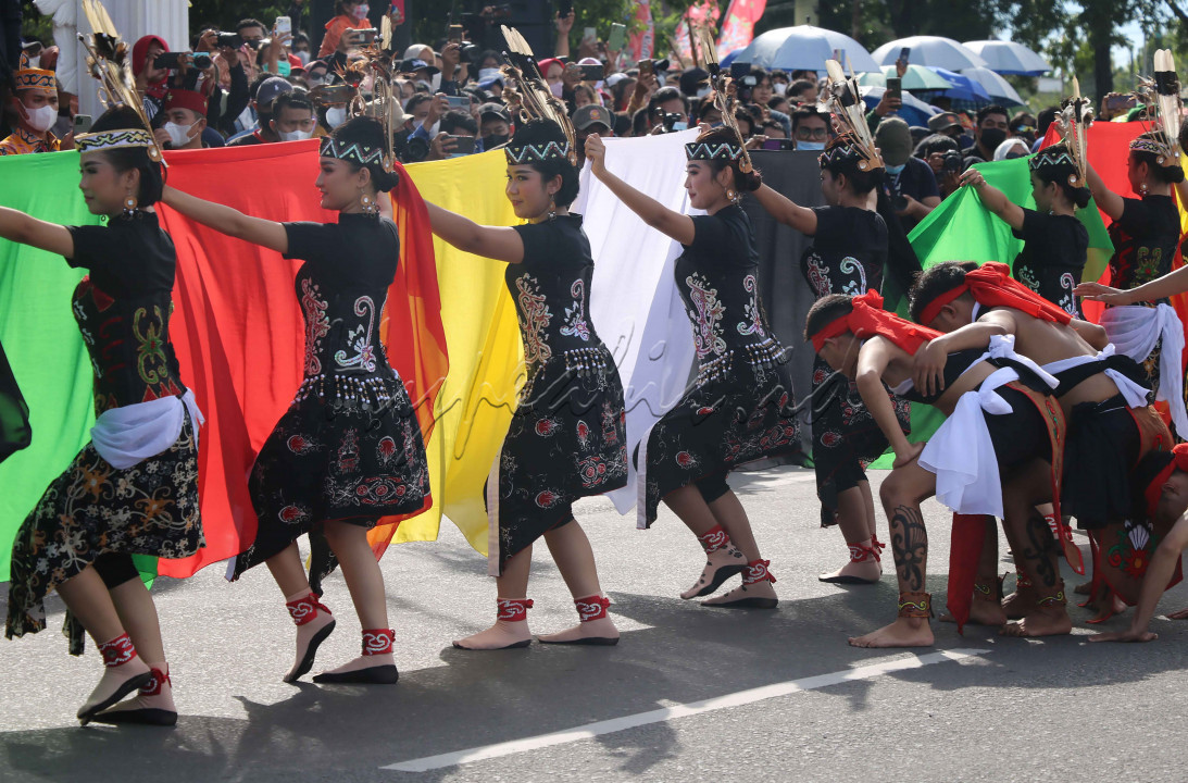 Para penari pria yang berada di balik selendang penari perempuan saat Festival Budaya Isen Mulang di Kota Palangka Raya, Kalimantan Tengah, pada Selasa (17/5/2022)