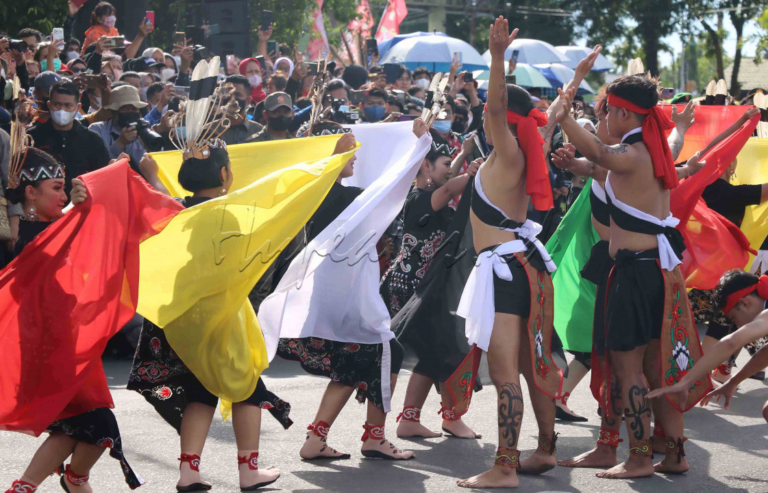Para penari pria membentangkan tangannya di hadapan penari wanita dan penonton saat Festival Budaya Isen Mulang di Kota Palangka Raya, Kalimantan Tengah, pada Selasa (17/5/2022). Foto: Marifka Wahyu Hidayat