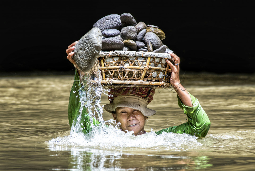 Kerja keras pencari batu kali yang harus merendam diri di derasnya aliran sungai Lodtunduh,Gianyar.Bali , tidak membuat ibu made patah semangat demi menghidupi keluarga dirumah.Dengan kedalam air 1,5 meter ibu made mencari batu yang akan diserahkan pada pengepul umkm untuk dijadikan ukiran wajah