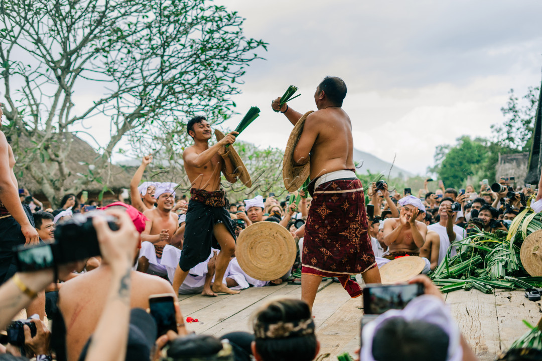 Tenganan Pegringsingan merupakan salah satu desa tua di Provinsi Bali, yeng terkenal dengan tradisi Mageret Pandan. Mageret Pandan (Perang pandan) adalah salah satu tradisi kearifan lokal yang masih bertahan di tengah gempuran globalisasi saat ini. Sebagai salah satu tradisi asli dari Desa Tenganan, Kecamatan Karangasem, Bali, Mageret Pandan kerap kali mendatangkan berbagai &nbsp;wisatawan mancanegara tiap kali upacaranya diselenggarakan. Tak khayal banyak pengaruh modernisasi yang masuk ke desa wisata ini, salah satunya seringkali wisatawan membawa berbagai macam kamera guna mengabadikan momen mageret pandan ini. Sehingga upacara kesenian ini mampu berkelana ke berbagai penjuru dunia melalui gambar serta film yang dihasilkan oleh para wisatawan yang berkunjung.<br />
<br />
Peran pandan dilakukan sebagai simbolisasi penghormatan kepada dewa Indra atau Dewa perang. Perang pandan merupakan bagian dari ritual Sasih Sembah. Sasih sembah ialah ritual terbesar yang ada di Desa Tenganan.<br />
<br />
Nama : Kadek Gopala Sai Wiswadara Arista&nbsp;<br />
Asal daerah : Bali<br />
Asal Universitas : Universitas Brawijaya&nbsp;<br />
Lokasi Pengambilan Foto : Desa Tenganan, Kecamatan Karangasem, Bali.&nbsp;<br />
Tanggal Pengambilan foto : 24 Juni 2022