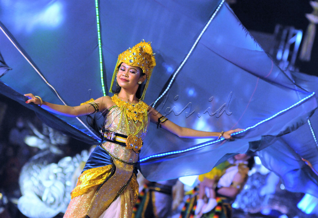 Tubuh penari yang lemah gemulai dengan tubuh yang gemerlap dan bersayap bak kunang-kunang dalam Wayang Jogja Night Carnival&nbsp;#7