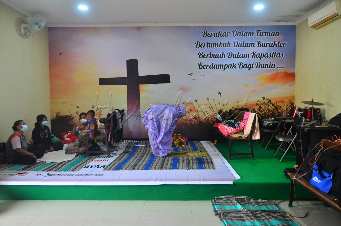 Pengungsi korban banjir melakukan shalat di ruang aula Gereja Kristen Muria Indonesia (GKMI) Tanjung Karang, Kudus, Jawa Tengah, Kamis (11/2/2021). Menurut pengurus gereja setempat, sebagai bentuk toleransi antarumat beragama serta wujud saling membantu kepada sesama, warga korban banjir dari berbagai agama dievakuasi ke gereja tersebut.