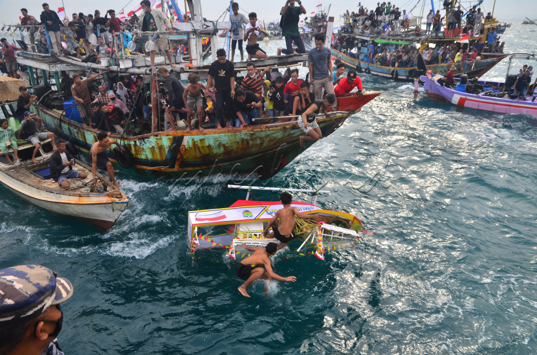 Tradisi Pesta Lomban"<br />
Warga berebut sesaji saat mengikuti prosesi Pesta Lomban di laut Jepara, Jepara, Jawa Tengah, Senin (9/5/2022). Pesta Lomban yang diadakan nelayan sepekan setelah Idul Fitri dengan melarung sesaji berupa kepala kerbau serta hasil bumi ke tengah laut itu sebagai bentuk ungkapan syukur dan harapan para nelayan kepada Tuhan Yang Maha Esa atas limpahan rezeki dan keselamatan saat melaut