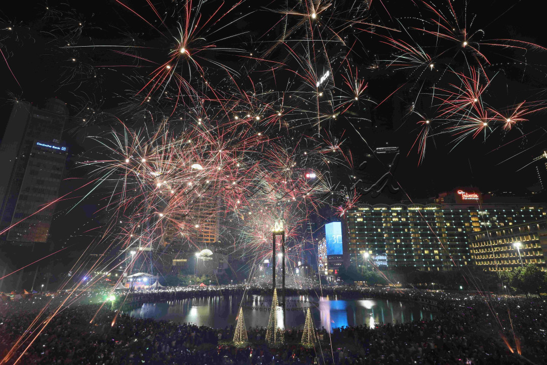 Kembang api menghiasi langit kawasan Bundaran Hotel Indonesia (HI), Jakarta, saat malam pergantian tahun baru 2023 di Jakarta, Minggu (1/1/2023).