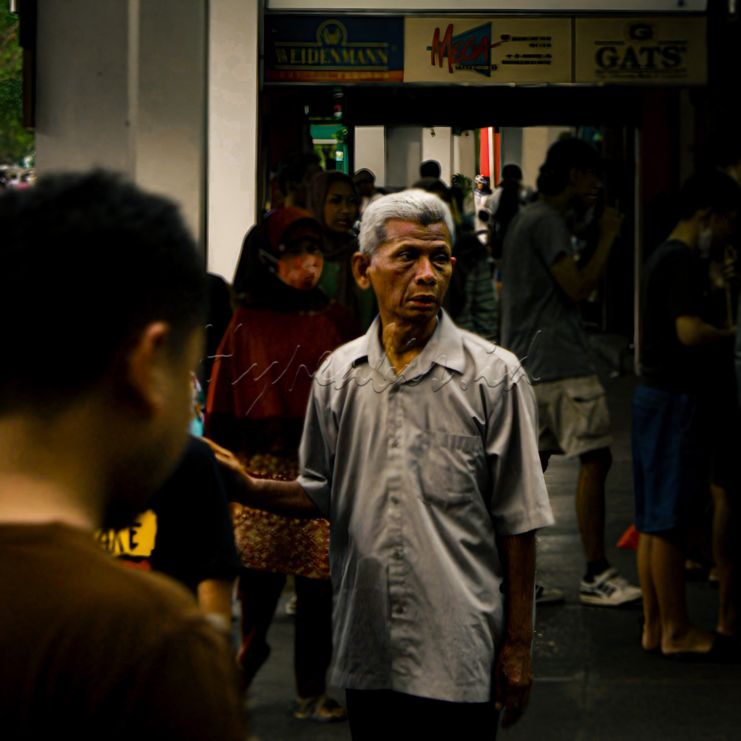 Seorang ayah dengan anaknya yang sedang melihat lihat isi malioboro yang penuh dengan keramaian