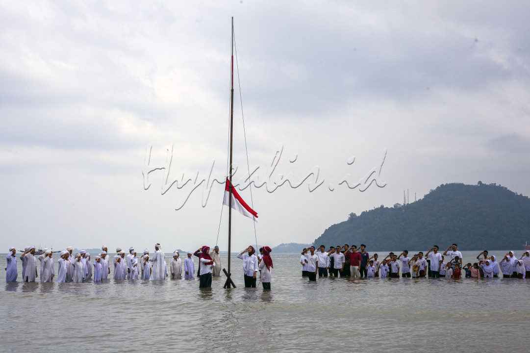 Sejumlah anak-anak dan juga pemuda pemudi tengah melaksanakan upacara memperingati Hari Kemerdekaan ke-78 RI di laut Taluak Buo, Kota Padang, Sumatra Barat, Kamis (17/8/2023)