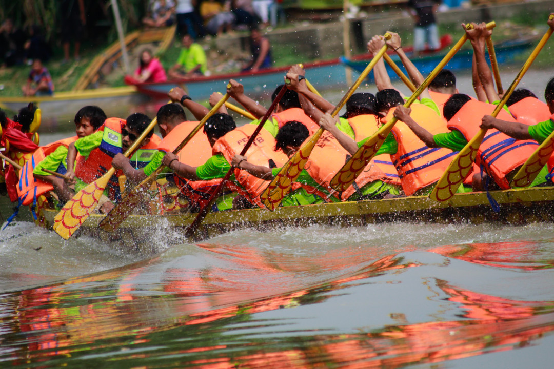Para pendayung bersemangat mendayung perahu melawan arus sungai Cisadane. Lomba dayung perahu ini digelar pada acara festival pehcun 2023 di Kota Tangerang.