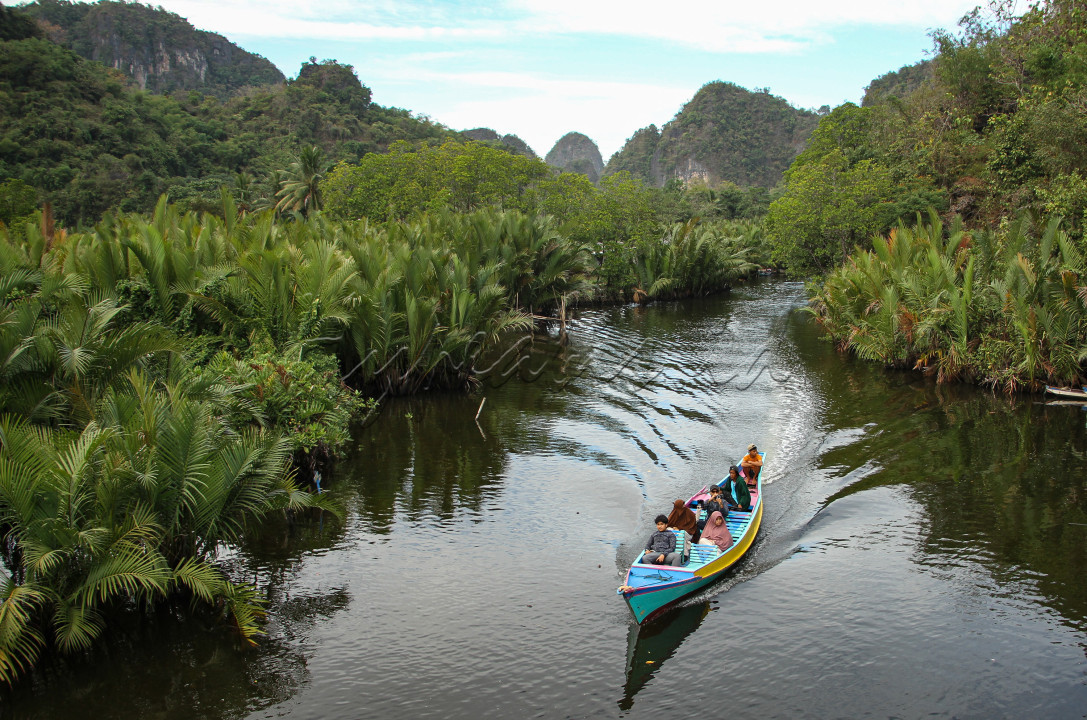 Wisatawan menggunakan perahu saat melitasi Sungai Pute yang berada di dalam kawasan Geopark Maros Pangkep di Kabupaten Maros, Sulawesi Selatan, Minggu (25/6/2023). Geopark Maros Pangkep yang telah resmi ditetapkan sebagai UNESCO Global Geopark (UGG) berdasarkan keputusan pada Sidang Dewan Eksekutif UNESCO ke-216 di Paris, Prancis pada 24 Mei 2023 tersebut menjadi tujuan wisatawan lokal maupun mancanegara.