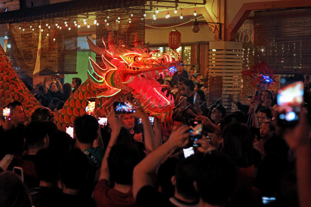 Antusias para penonton dengan gawainya saat merekam dan mengabadikan moment atraksi iring-iringan Naga pada festival Malam Lampion di Kota Singkawang , Kalimantan Barat . Festival Malam lampion ini merupakan salah satu rangkaian acara dari Festival Imlek &amp; Capgomeh 2023 di Kota Singkawang .