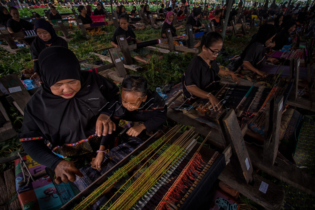Seorang wanita dari suku sasak mengajari anaknya menenun di Desa Sukarara, Lombok Tengah. Menenun secara turun temurun diajari pada anak perempuan sasak sebelum beranjak dewasa.