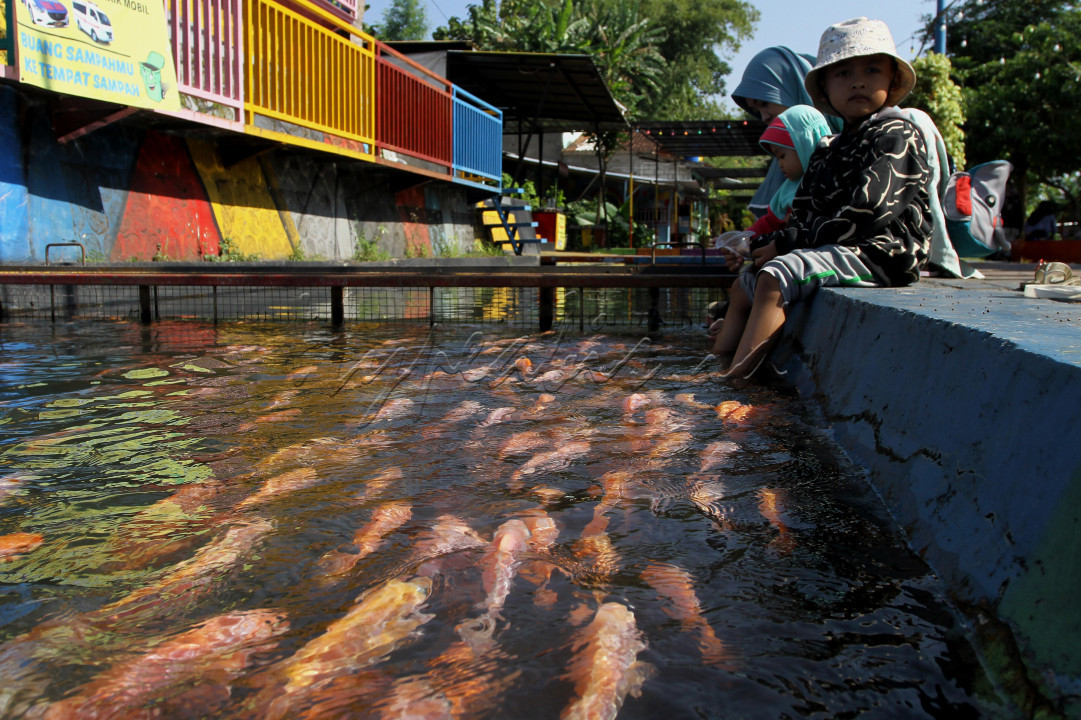 Warga mengunjungi kawasan Bendungan Lepen, Sungai Gajah Wong, Umbulharjo, Yogyakarta. Saluran irigasi Sungai Gajah Wong yang dimanfaatkan warga sekitar untuk beternak ikan nila dan koi serta ditata dengan rapi, saat ini menjadi alternatif destinasi wisata di Yogyakarta.