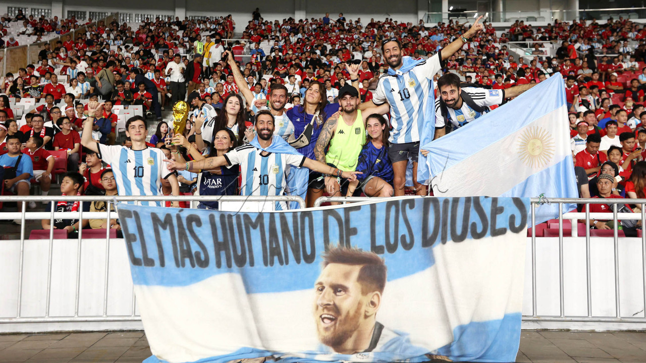 Suporter Timnas Argentina membentangkan spanduk bergambar Lionel Messi saat menyaksikan laga melawan Timnas Indonesia pada FIFA Matchday 2023 di Stadion Utama Gelora Bung Karno, Senin (19/6/2023). (Foto: Iqbal Ichsan)
