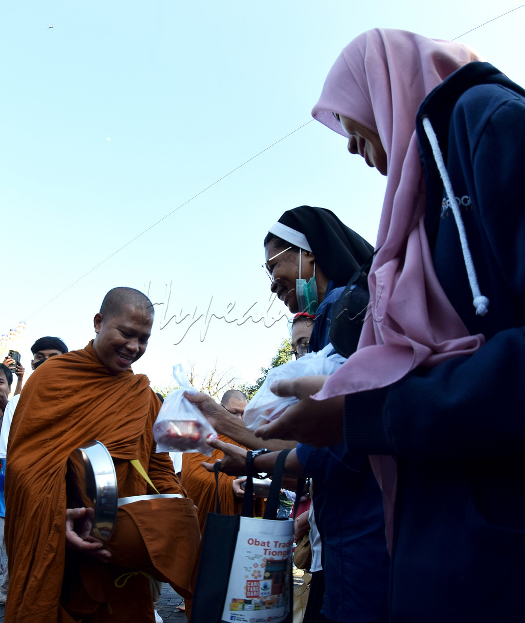 Acara Pindapata yang digelar oleh umat Budha, di kota Solo, Jawa Tengah, dimana seorang Kristiani dan seorang Muslimah ikut berpartisipasi dalam berbagi, sebagai ikatan cinta kasih damai di bumi.