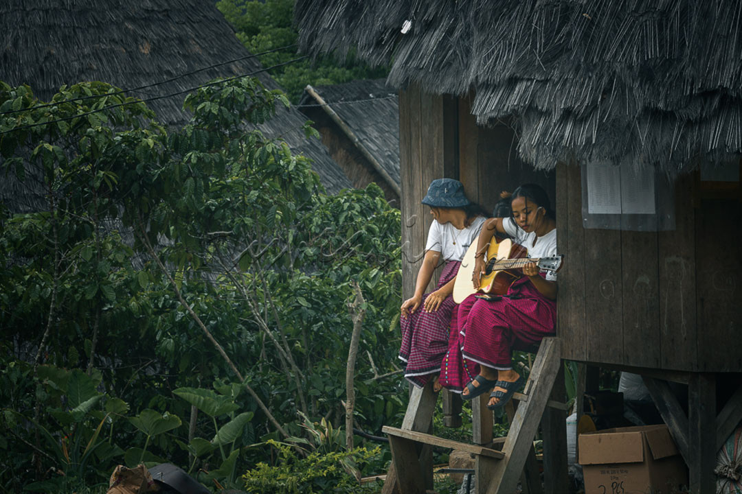 Beberapa remaja putri masyarakat adat Desa Waerebo sedang bermain gitar dan bernyanyi bersama.