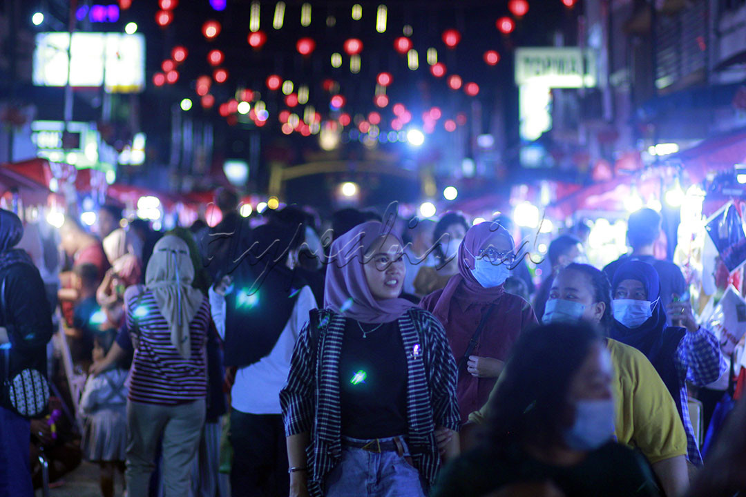 Wanita muslim sedang melihat pedagang makanan saat bazar malam menjelang perayaan imlek di Tanjungpinang, Kepri 14 Januari 2023.&nbsp;Kota Tanjungpinang adalah kota yang dihuni beragama etnis dan suku agama yang hidup rukun.