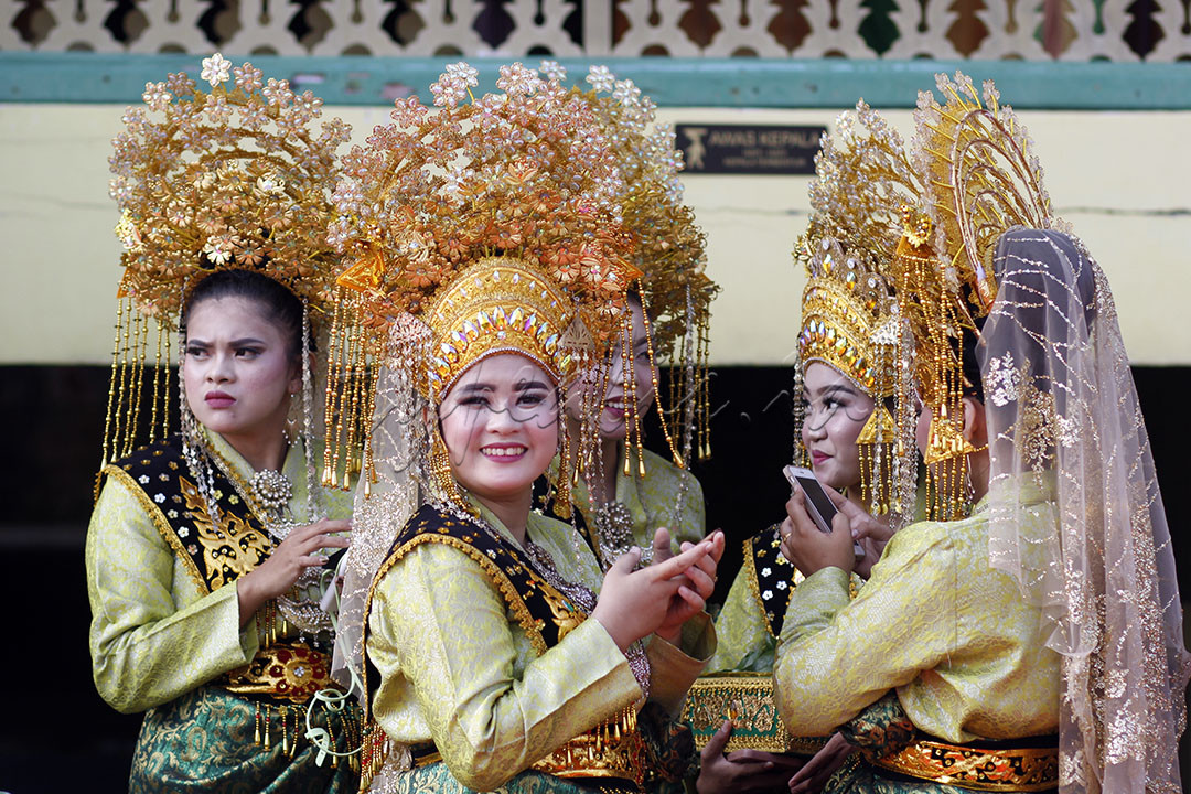 Wanita dengan pakaian adat melayu sedang bermain gawai di Pulau Penyengat, Tanjungpinang, Kepri 29 Juli 2023. Kota Tanjungpinang adalah kota yang dihuni beragama etnis dan suku agama yang hidup rukun.