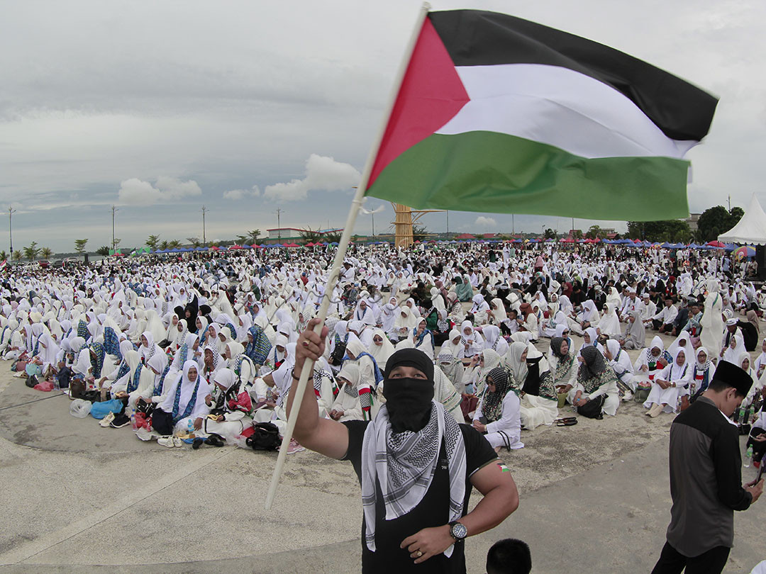Seorang warga sedang mengibarkan bendera Palestina saat aksi solidarita Palestina di Tanjungpinang, Kepri, 19 November 2023.
