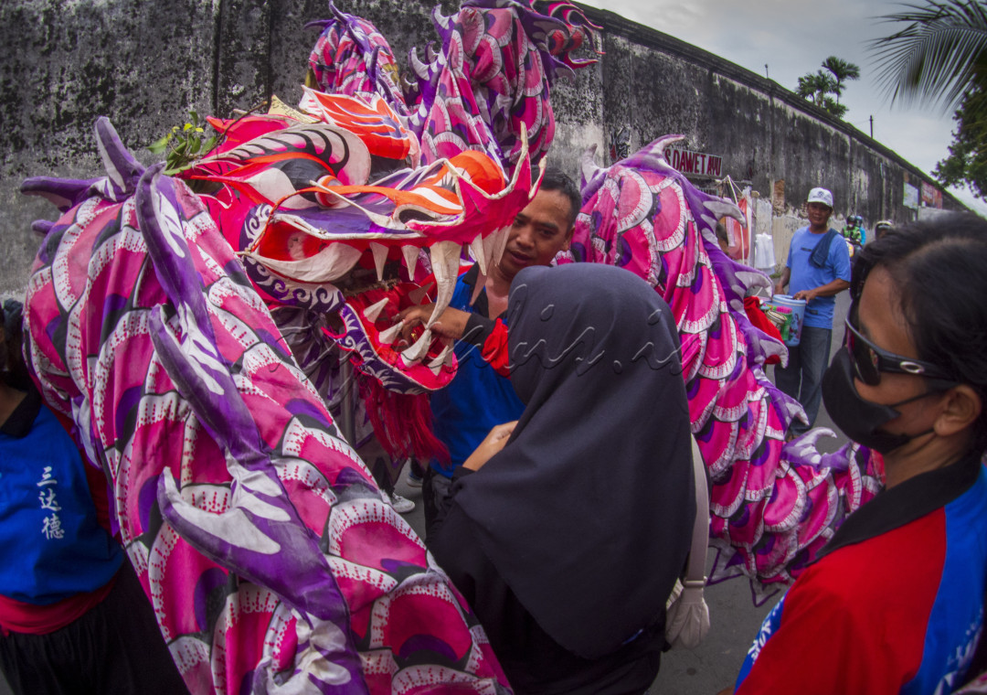 kegiatan mengelilingi kota sambil mengarak naga
