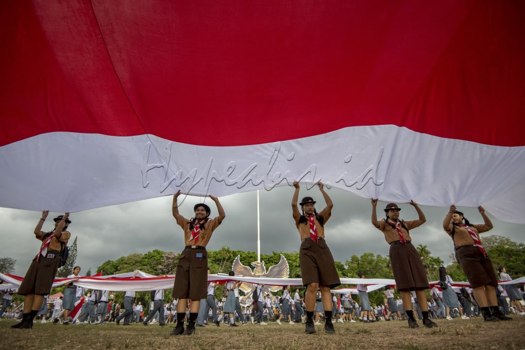 Semangat nasionalisne anak-anak sekolah dasar di Kota Denpasar saat memperingati hari Pahlawan dengan membentangkan bendera merah putih untuk mengenang jasa-jasa pahlawan yang sudah berjuang untuk Negara Kesatuan Republik Indonesia&nbsp;