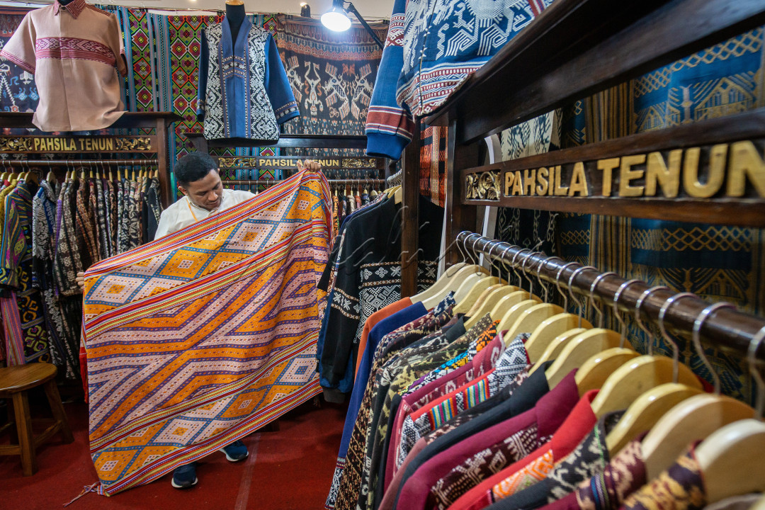 Seorang pekerja sedang memamerkan Kian tenun khas NTT disaat pameran Kain Batik dan Tenun di Graha Manggala Siliwangi, yang dilaksanan dari tanggal 29 November - 3 Desember 2023. Indonesia sangat kaya akan keberadaan dan keberagaman Wastranya, salah satunya Pahsila Tenun, yang memiliki motif beragam dan Indah serta kualitas yang baik. Kemajuan Wastra indonesia ini diiringi dengan meningkatnya kemajuan Ekonomi, khususnya bagi para Pengrajin dan Pekerja di sektor UMKM.